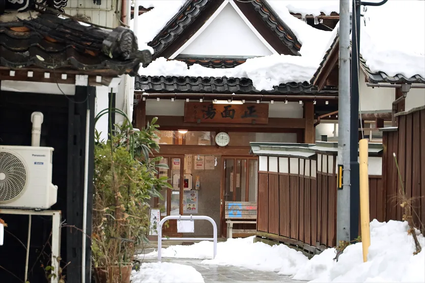 Shomen-yu public bath among the snow-covered buildings of Yutagawa Onsen
