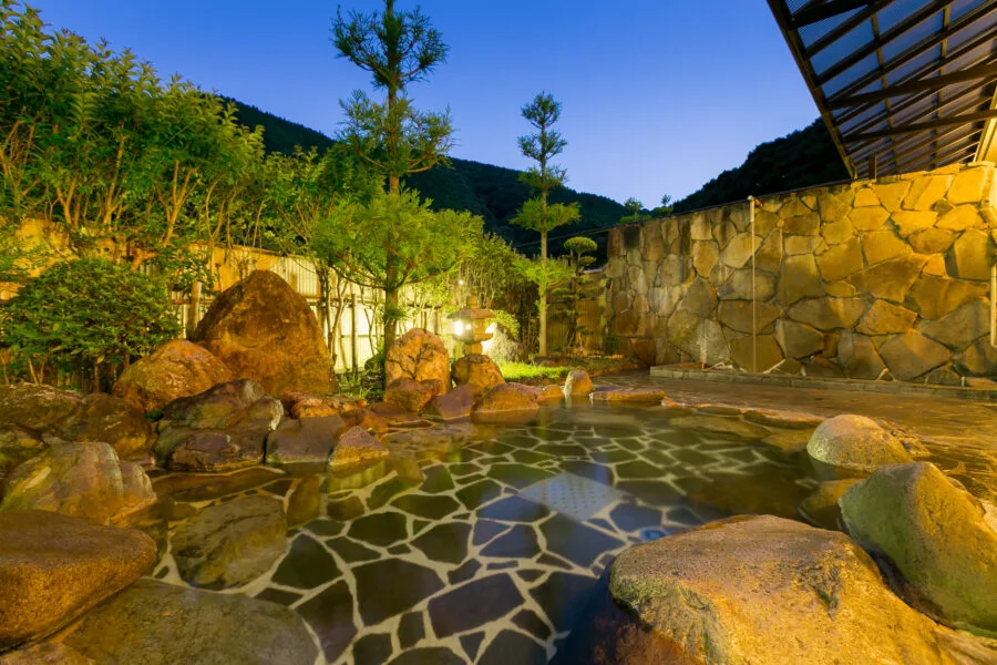Outdoor bath at Ichinomata Kanko Hotel, framed by the surrounding forest