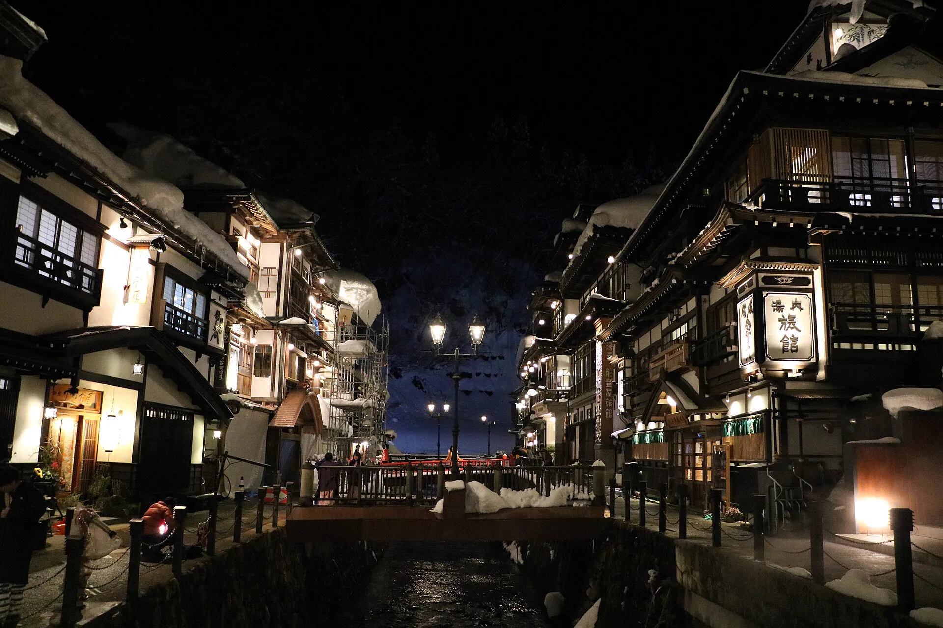Ginzan Onsen’s wooden riverside inns illuminated on a snowy winter night